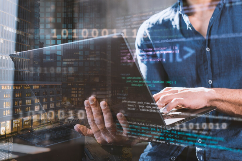 Man using a laptop with code and city skyline overlaid, symbolizing the global data industry.