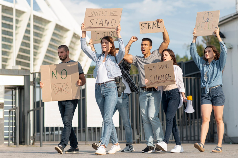 Group of young protesters holding signs and marching for change, symbolizing global protest movements.