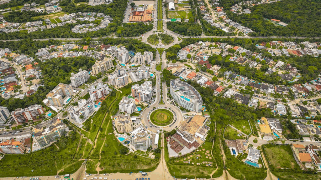 Aerial view of a circular boulevard and mixed housing surrounded by greenery, illustrating the future of global cities.