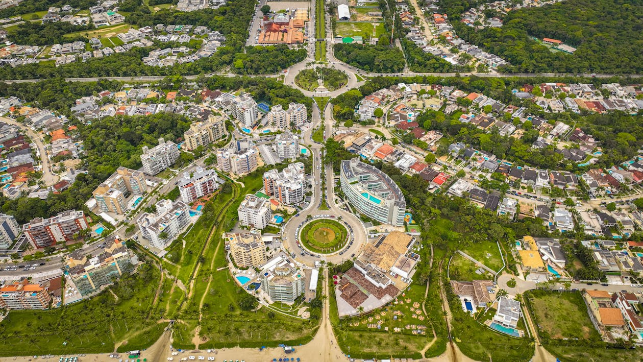 Aerial view of a circular boulevard and mixed housing surrounded by greenery, illustrating the future of global cities.